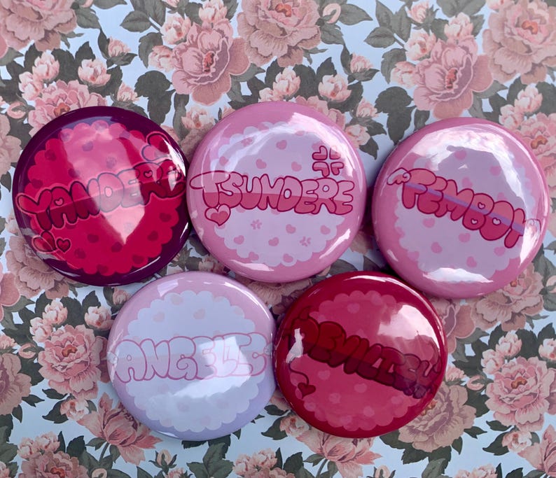 May include: Five round pink and purple buttons with different text on each. The text on the buttons reads "Yandere", "Tsundere", "Femboy", "Angel", and "Devil".
