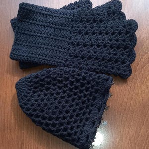 May include: Black crocheted hat with a star-shaped trim. The hat is made of a fine, open-weave crochet fabric.