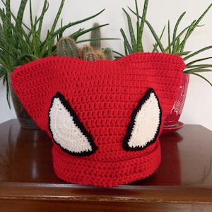May include: Red crocheted hat with white and black spider-man inspired eyes.
