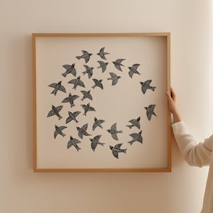 May include: A framed print showing a flock of black birds in flight, arranged in a circular pattern against a cream background. The wooden frame adds a natural touch to this artwork, suitable for home decor.