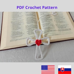May include: White crocheted cross bookmark with a red heart in the center. The bookmark is laying on an open book with text in a foreign language. The bookmark is a PDF crochet pattern.
