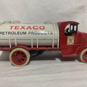 May include: Red toy truck with a white tank that says "Texaco Petroleum Products".