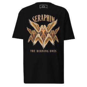May include: A black t-shirt featuring a graphic print of multiple golden-winged figures with fiery bodies. The text SERAPHIM is arched above the wings, and the text THE BURNING ONES is printed in gold below the central figure on the chest.