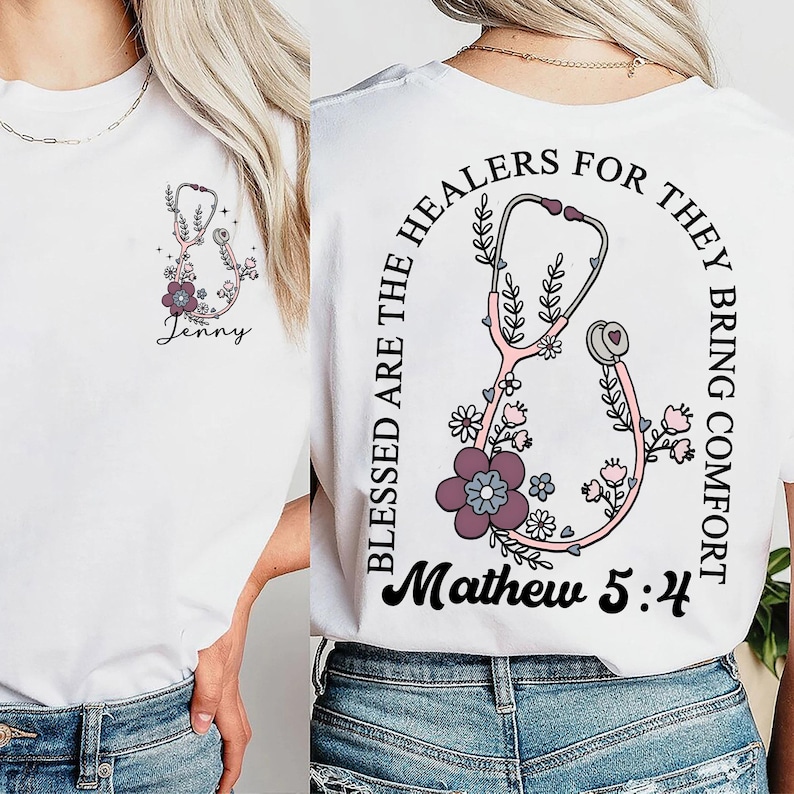 May include: White t-shirt featuring a pink stethoscope design with floral accents and the name "Jenny". The back of the shirt displays a similar stethoscope design with the text "Blessed are the healers for they bring comfort" and "Mathew 5:4".