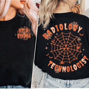 Może przedstawiać: Czarny T-shirt z pomarańczowym wzorem pajęczyny i tekstem "Radiology Technologist" w przerażającym stylu. Pajęczyna zawiera nietoperze, pająki i symbole radioaktywne.