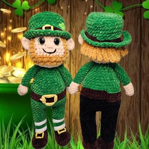 May include: A green crocheted leprechaun doll with a brown belt and brown shoes. The doll is wearing a green hat with a gold buckle and a shamrock.