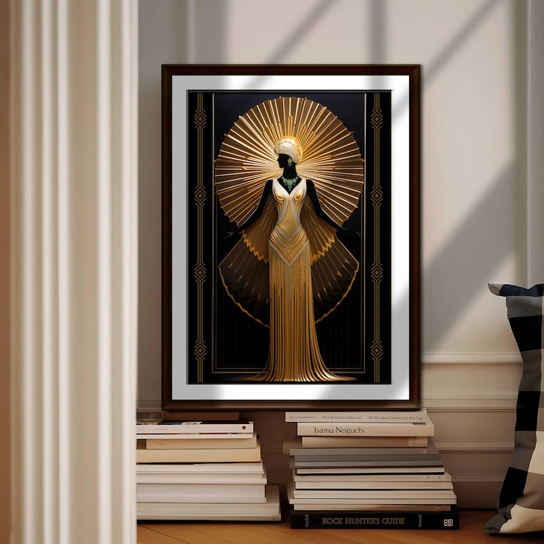 May include: Art Deco style framed print featuring a woman in a gold gown with a sunburst halo. The artwork has a black background with gold geometric accents. The print is displayed on a wall above a stack of books.