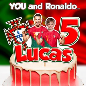 May include: A red cake with white icing, topped with a cake topper featuring Cristiano Ronaldo and a young boy in Portugal soccer jerseys. The topper includes the text "YOU and Ronaldo..." and "Lucas 5". The Portuguese flag and emblem are also visible.