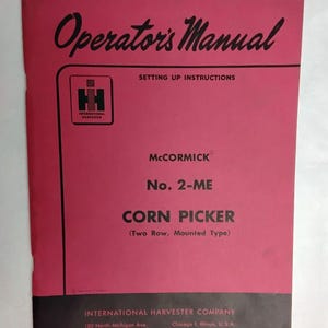 May include: A pink and black operator's manual for a McCormick No. 2-ME corn picker, two row, mounted type. The cover features the International Harvester logo, setting up instructions, and the company address in Chicago, Illinois, U.S.A.