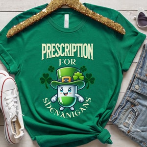 May include: Green t-shirt with a cartoon pill wearing a leprechaun hat and the text "Prescription for Shenanigans".