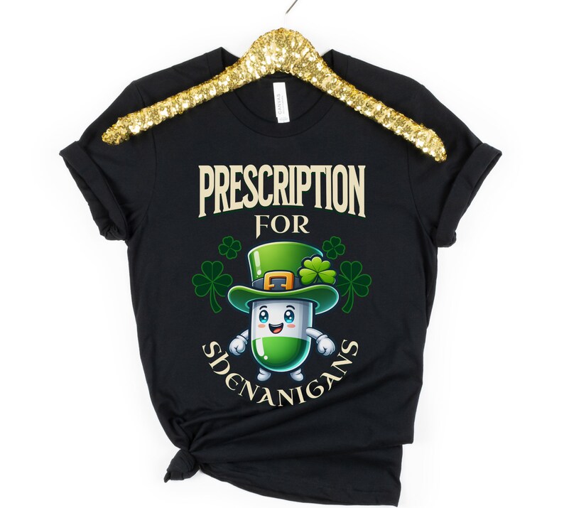 May include: Black t-shirt with a green cartoon pill wearing a leprechaun hat and the text "Prescription for Shenanigans".