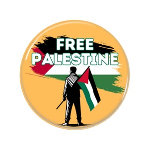 May include: A yellow button featuring a black and green brushstroke design. The text "FREE PALESTINE" is written in white letters. A person in a black silhouette holds a Palestinian flag.