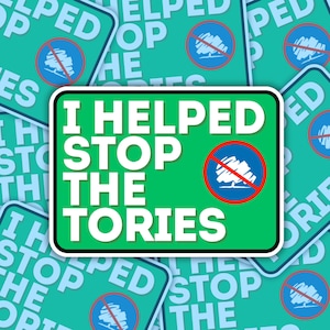 May include: A green sign with white text that reads "I helped stop the tories". The sign has a red circle with a diagonal line through it and a stylized tree inside the circle. The sign is surrounded by other signs with similar text and imagery.