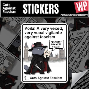May include: A rectangular sticker featuring a grey cat dressed in a black cape and hat, holding a Guy Fawkes mask and a small knife. The background shows the Palace of Westminster. Text reads: Voila! A very vexed, very vocal vigilante against fascism.