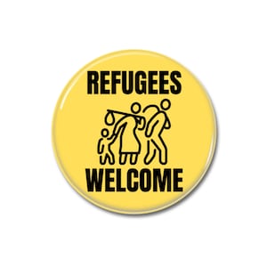 May include: Yellow button with black text that reads "Refugees Welcome". A black and white illustration of a family of four with a suitcase and a stick.