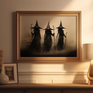 May include: A framed painting of three witches in black robes and pointed hats, walking in a misty forest. The painting is in a gold frame and hangs on a beige wall.