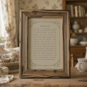 May include: A framed print of Psalm 23, with a rustic, weathered wooden frame. The text is printed in a classic serif font on a cream-coloured background, with decorative floral accents. The frame is a warm brown colour.
