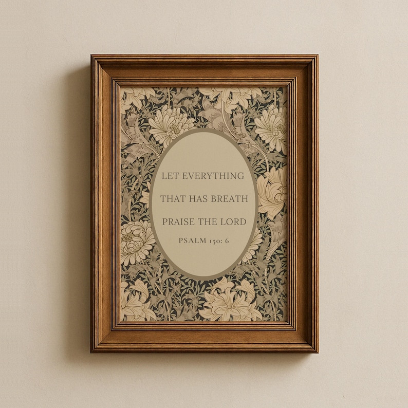 May include: A framed print with the text "LET EVERYTHING THAT HAS BREATH PRAISE THE LORD" and "PSALM 150: 6" in an oval. The background has a floral pattern in beige, black, and cream. The frame is a dark brown colour.