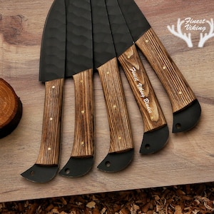 May include: Set of five black knives with wooden handles. The handles are a dark brown wood with a light brown grain. The knives have a hammered finish and are engraved with "Finest Viking Blades".