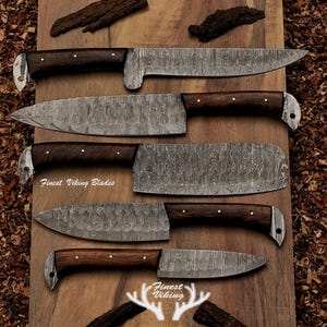 May include: An assortment of five Damascus steel knives with dark wooden handles and silver accents. The blades have a unique patterned design. The text "Finest Viking Blades" is visible on the wooden surface.