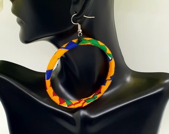 May include: A pair of large hoop earrings made of fabric. The earrings are yellow, blue, green, and red.