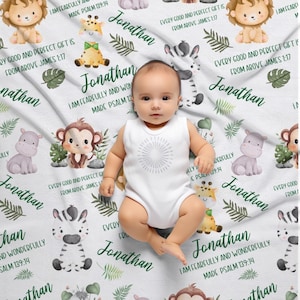 May include: A white baby blanket with a jungle animal theme. The blanket features a variety of animals, including monkeys, zebras, giraffes, and hippos. The blanket also has green leaves and the text "I am fearfully and wonderfully made Psalm 139:14" and "Every good and perfect gift is from above James 1:17".