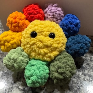 May include: A white ceramic mug with a black handle and the text "But First, Coffee" in a black, handwritten-style font. The mug is on a white surface.