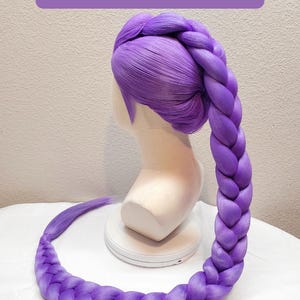 May include: A 50-inch dark purple wig styled with a large, thick braid that starts at the crown and extends downward. The wig is displayed on a mannequin head. The text 50" Dark Purple w/ Tulle is visible at the top of the image.