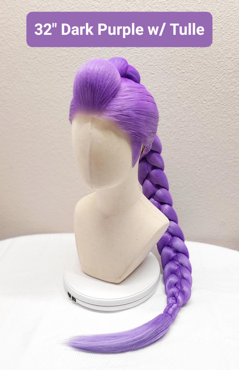 May include: A 32-inch dark purple wig styled with a high, voluminous pompadour at the front and a long, thick, single braid extending down the back. The wig is displayed on a mannequin head and features the text 32" Dark Purple w/ Tulle.