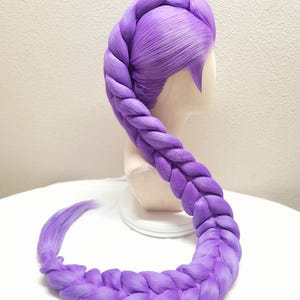 May include: A vibrant purple wig styled with a large, thick, single braid that starts at the crown and curves downward in an S-shape. The hair is smooth and uniform in color, featuring a side-swept bang section and a long, braided tail.