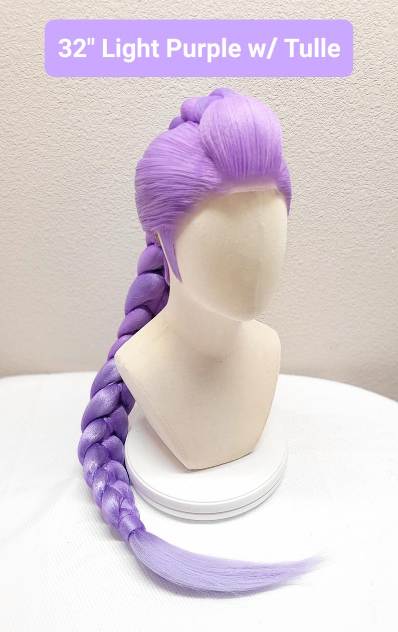May include: A 32-inch light purple wig styled with a voluminous top section and a long, thick, single braid that extends down the back. The wig features a sheer tulle lace front hairline and is displayed on a neutral-colored mannequin head.