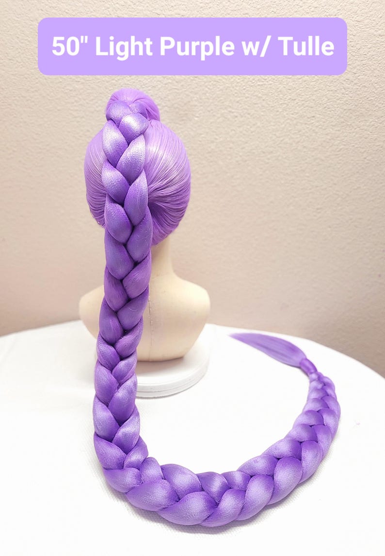 May include: A 50-inch light purple braided hair extension styled in a high ponytail on a mannequin head. The braid is thick and long, extending downward and curving across the surface. The text 50" Light Purple w/ Tulle is visible at the top.