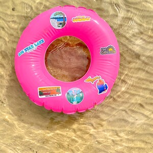 May include: Pink inflatable pool float with various stickers, including "Big Star Lake", "To the Lake", "I'm Golden", and a Michigan state outline.