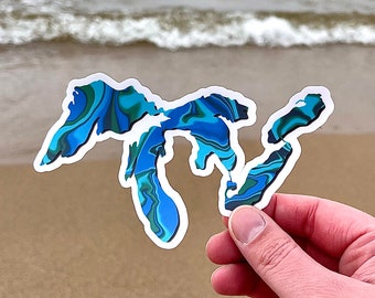 May include: A blue and green marbled sticker of the Great Lakes. The sticker is cut out in the shape of the Great Lakes.