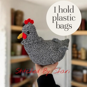 May include: A handmade crochet chicken in black and white, with a red comb and wattle, and a yellow beak. The text "I hold plastic bags" is in a white circle. The text "Stitched By Shari" is in red cursive.