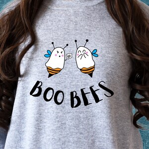 Puede incluir: Una sudadera gris con un gráfico de dos fantasmas de dibujos animados vestidos de abejas. El texto "BOO BEES" está impreso debajo de los fantasmas.