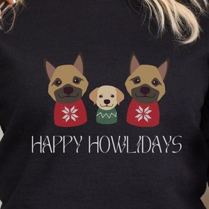 May include: Black sweatshirt with a graphic of three dogs wearing Christmas sweaters. The text "Happy Howlidays" is printed below the dogs.