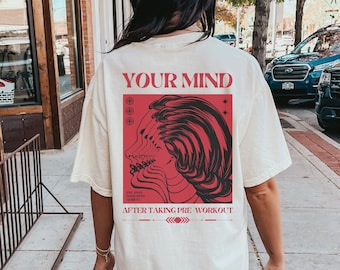 May include: A white t-shirt with a red graphic on the back. The graphic features a stylized image of a face with the text "YOUR MIND" and "AFTER TAKING PRE WORKOUT".