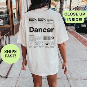 Könnte beinhalten: Ein weißes T-Shirt mit schwarzem Text, der "100% 100% Selbstvertrauen Geschickt Tänzer" lautet und eine Zutatenliste: "Inspiriert von einem kreativen Performer mit Anmut und Eleganz in jeder Bewegung. Ausdruck, der voller Energie ist. Synchronisiert mit Musik. Emotionales Wesen. Mit Liebe gemacht. Vorsichtig behandeln. Benötigt Koffein."