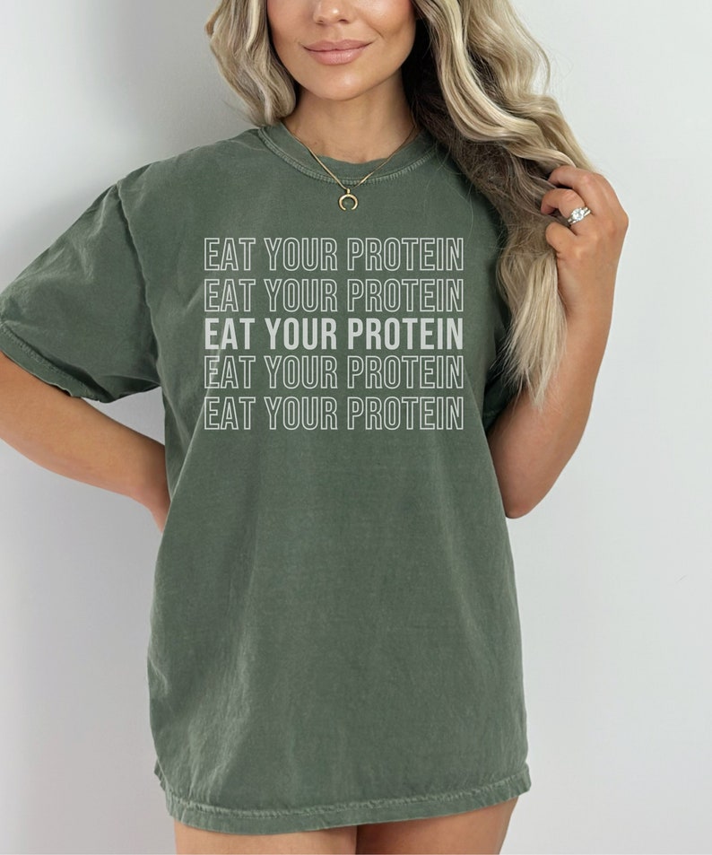 May include: A green t-shirt with the text "EAT YOUR PROTEIN" repeated five times in white.