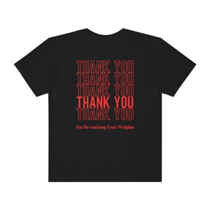 Peut inclure: T-shirt noir avec le texte "THANK YOU" r&eacute;p&eacute;t&eacute; cinq fois en rouge, suivi du texte "For Re-racking Your Weights" en rouge.