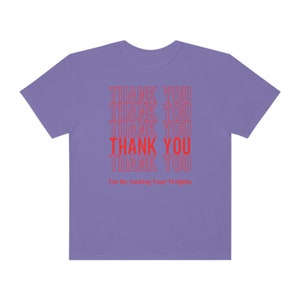 Peut inclure: T-shirt violet avec le texte "THANK YOU" r&eacute;p&eacute;t&eacute; cinq fois en rouge. Le texte est empil&eacute; verticalement et la ligne du bas dit "For Re racking Your Weights".