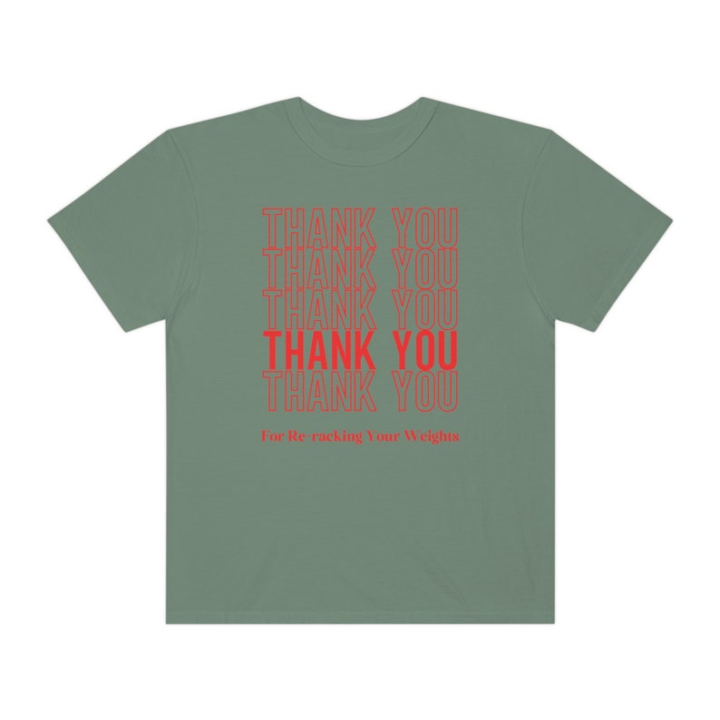 Peut inclure: Un t-shirt vert sauge avec le texte "THANK YOU" r&eacute;p&eacute;t&eacute; six fois en rouge. Le texte est empil&eacute; verticalement et la ligne du bas indique "For Re-racking Your Weights".
