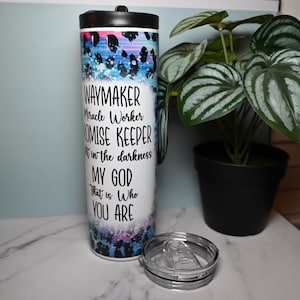 Könnte beinhalten: Ein weißer Edelstahlbecher mit einem abstrakten Design in Blau, Rosa und Lila. Der Becher hat einen schwarzen Deckel und einen schwarzen Griff. Auf dem Becher steht der Text "WAYMAKER Miracle Worker PROMISE KEEPER in the darkness MY GOD That is Who YOU ARE".