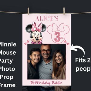 May include: Pink Minnie Mouse themed photo booth prop with a cut-out for a picture. The prop features Minnie Mouse with a pink bow and the text "ALICE'S Birthday Bash". It also has a pink bow with the number "3rd" in the corner. The text "Fits 2-3 people" is written on the right side of the image.