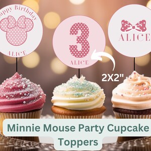 May include: Three pink and white cupcake toppers featuring a Minnie Mouse head with a bow, the number 3, and a bow with the name "Alice". The toppers are 2 inches by 2 inches and are shown on top of cupcakes.