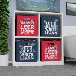 Puede incluir: Cuatro cubos de almacenamiento de tela roja y azul con personajes de dibujos animados coloridos y las palabras "Let's Read Write Learn" y "Vamos Leer Escribir Aprender" en ellos.