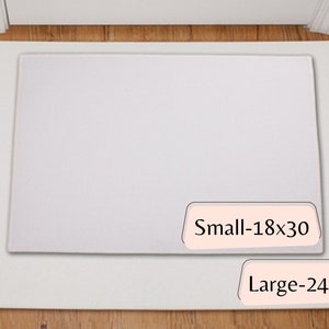 May include: Two white rectangular doormats, one inside the other, on a wooden floor. The smaller mat is labeled "Small-18x30" (approx. 46x76 cm) and the larger mat is labeled "Large-24x36" (approx. 61x91 cm).