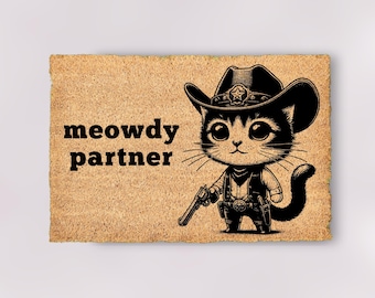 May include: A brown doormat with the text "meowdy partner" and a cartoon illustration of a black cat wearing a cowboy hat and holding a gun.
