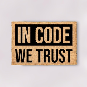 May include: A brown doormat with the text "IN CODE WE TRUST" in black lettering.